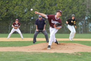 Nick Massa, pitching for the Buccaneers, tosses a fastball as umpire Tom Pegut keeps an eye on the ball.