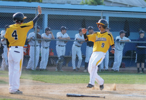 SJV’s Nick Gugliara is greeted by teammate Drew Fisher as he crosses the plate and scores a run for the Lancers. The Lancers won with a score of 13-9 . --Photo by Sean Simmons
