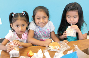 Three friends, Melissa, Irene and Juliette, enjoy a healthy lunch during a summer day session at the Boys and Girls Club in Red Bank. 