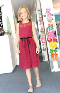Caroline Durkin, 10, tries on the burgundy Catherine Lace Dress by Blush By Us Angels at Moon Child in Fair Haven.