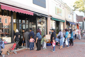Children and their parents line up in front of the  Doc Shoppe on Broad Street to receive free shoes. Owner Dean Ross gave away about 600 pairs of children’s shoes during the past two Sundays. 