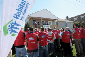 Lowe’s volunteers gather in front of the new home on Ocean Avenue for the official ribbon-cutting ceremony. 