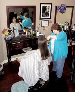 Cindy Fligor, president of the Atlantic Highlands Chamber of Commerce, cuts the hair of Amy Porter, 30, of Highlands at her Salon at 68 hair salon and spa on First Avenue.