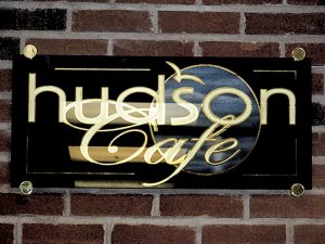 A gold gilded sign for Hudson Cafe in New York. 