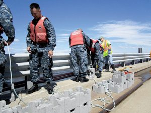 Workers ready oyster castles on the pier at Naval Weapons Station Earle. The castles were lowered into the shallow Raritan Bay waters, creating an artificial reef.