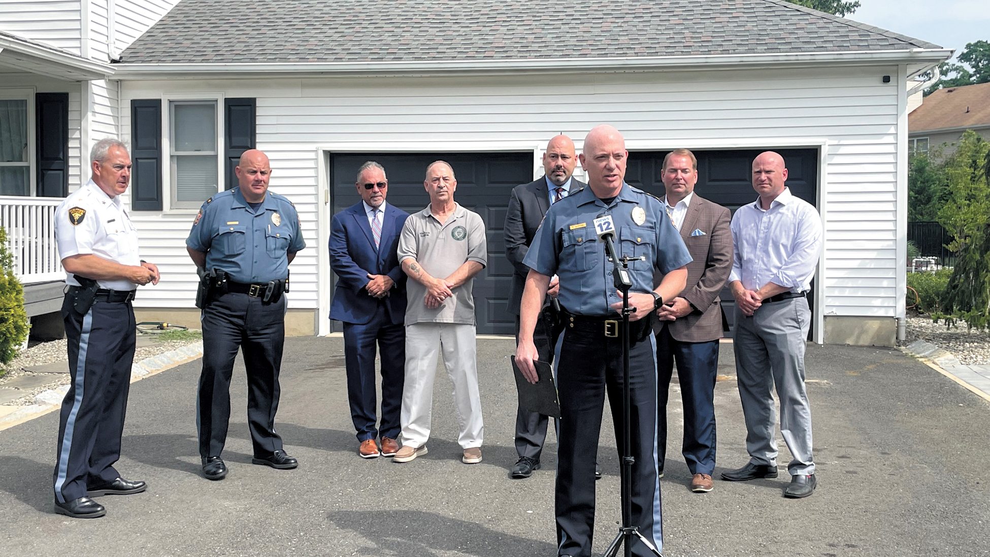 Joined by local and county law enforcement officials, Hazlet police chief Ted Wittke, front, launched the township’s home security survey program with a demonstration at one resident’s home. From left: Michael Kelly, Christopher Acevedo, John McCabe, Michael Sachs, Raymond Santiago, Shaun Golden and Rob Bengivenga. Stephen Appezzato
