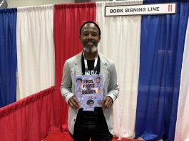 Author Sean Qualls holding his book at the National Book Festival