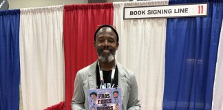 Author Sean Qualls holding his book at the National Book Festival